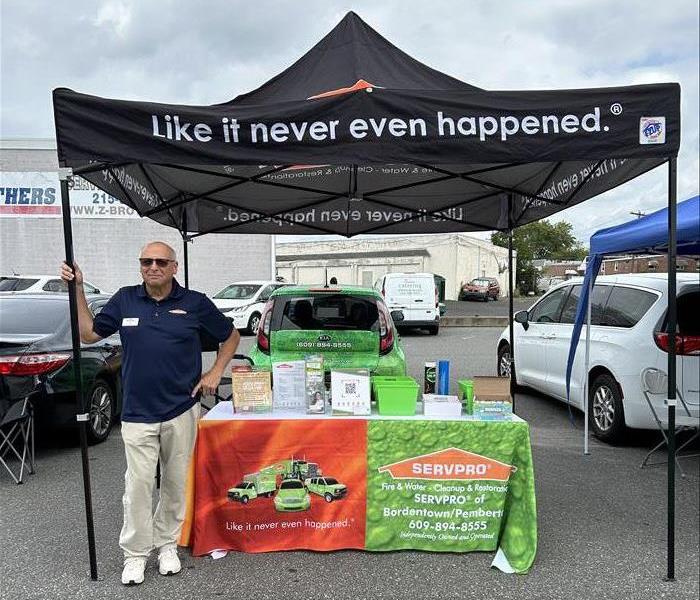 man standing next to company tent