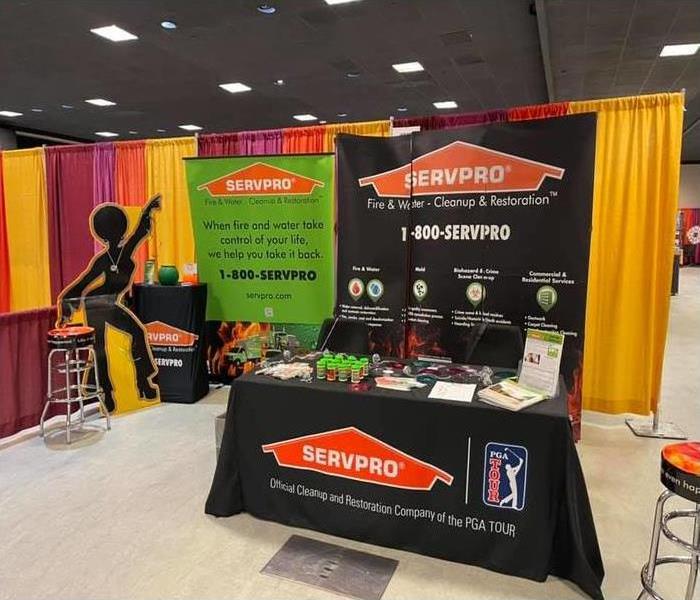 a SERVPRO booth at a trade show including a table, backdrop, and giveaways